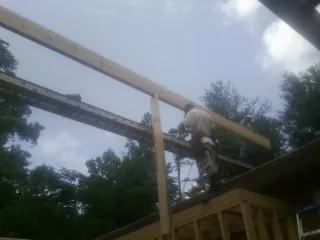 Carpenter setting a ridge beam over a new addition frame — Ice Dam Removal by Roofing Brothers in Redding