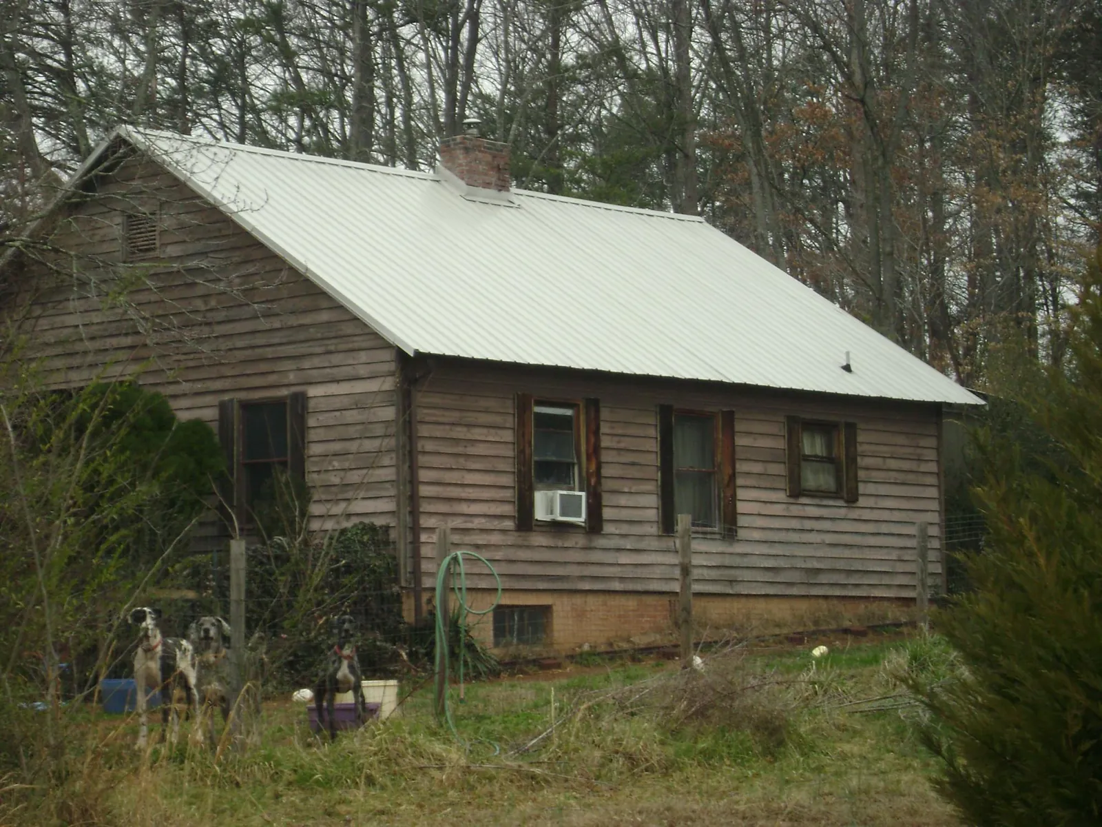White metal roof on an old wood sided farmhouse, from a Metal Roof Installation job in Redding